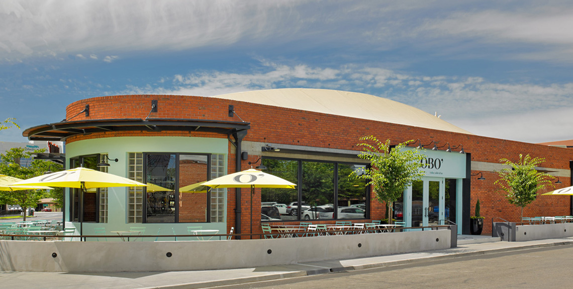Exterior of OBO’ Italian Sacramento with outdoor seating and yellow umbrellas